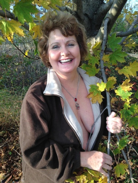 Older woman Busty Bliss exposes her big natural tits while under a tree 62386102