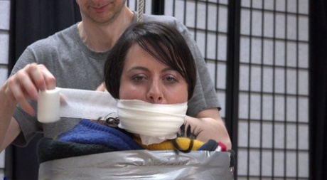Busty brunette finds herself silenced with medical tape while being mummified 54037291