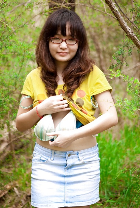 Petite Asian girl in glasses bares hairy vagina outdoors after slow strip 97142742
