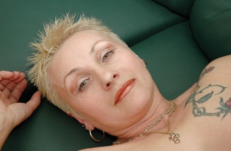 Short haired tattooed granny with pierced nipples taking off her lingerie 90931516